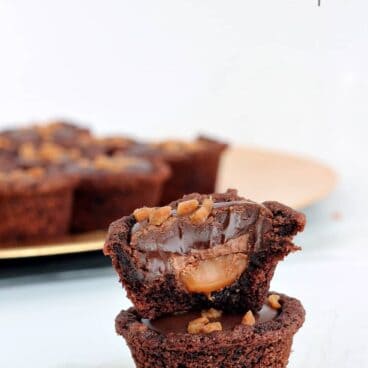 Double Chocolate Caramel Cookie Cups: super easy cake mix cookie cups stuffed with caramel, topped with a chocolate truffle and Skor bits! www.thereciperebel.com