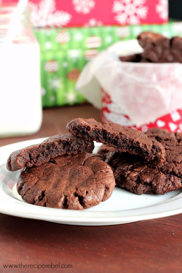 chocolate peanut butter cookies on white plate with two cookies broken in half