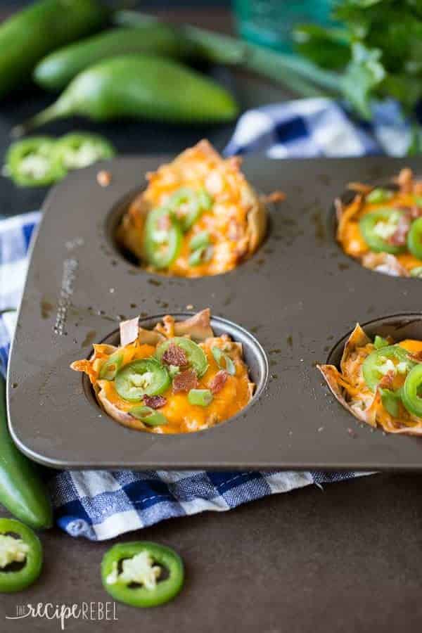 jalapeno popper wonton cupcakes in muffin pan on top of blue checked towel