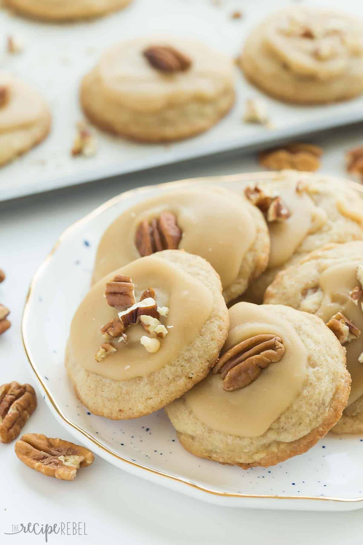 brown sugar pecan cookies on white plate with more on sheet pan in the background