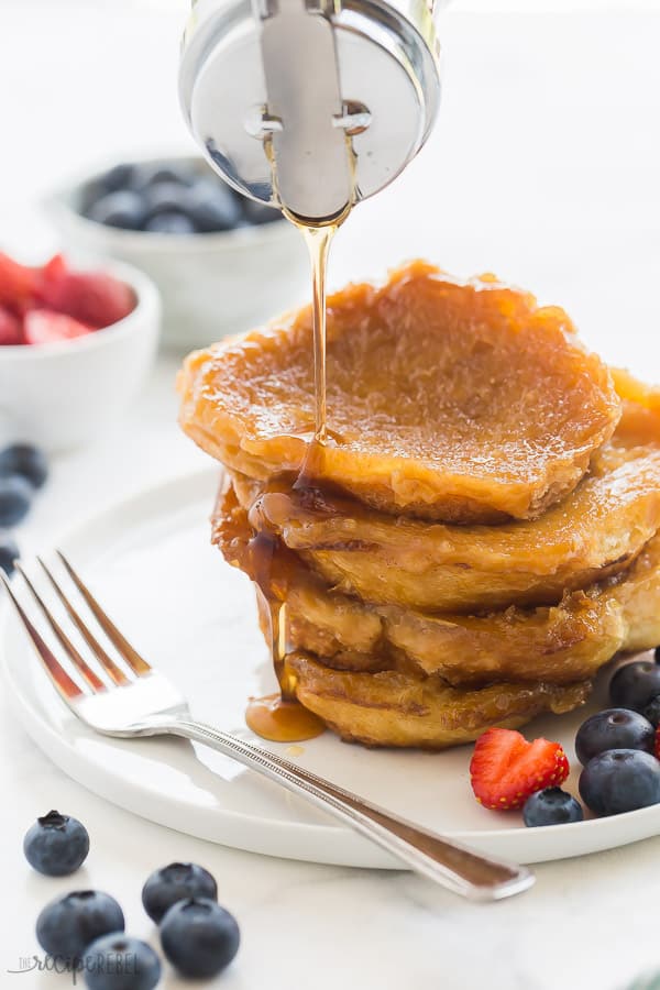 caramel french toast stack on white plate with syrup drizzled over top