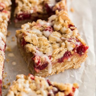 close up image of one cranberry bar with drizzle of glaze