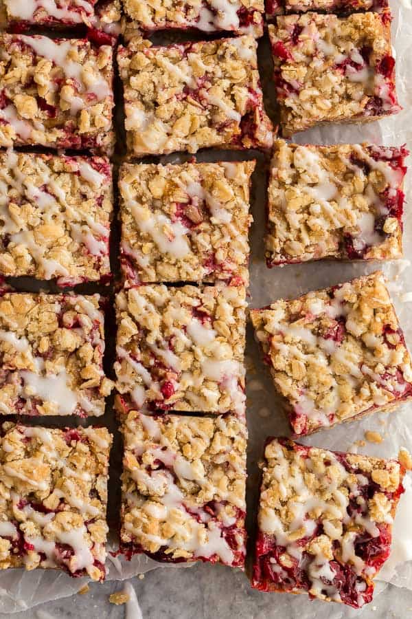 These Cranberry Caramel Bars have a crumbly oat crust, filled with tart cranberries and sweet caramel -- a match made in heaven! #dessert #cranberry #christmas #recipes overhead image of cranberry bars drizzled with glaze