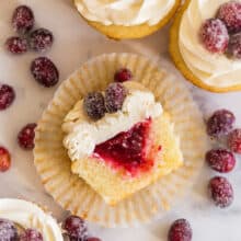 cranberry vanilla cupcakes cut in half and lying on paper liner