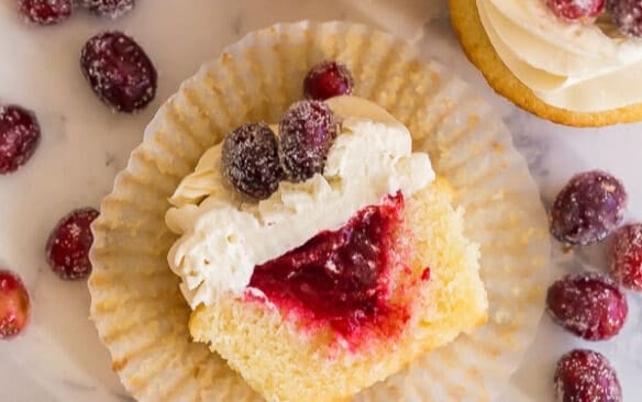 cranberry vanilla cupcakes cut in half and lying on paper liner