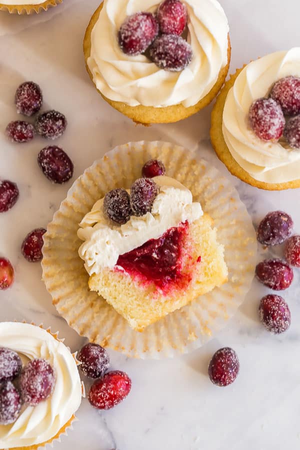 cranberry vanilla cupcakes cut in half and lying on paper liner