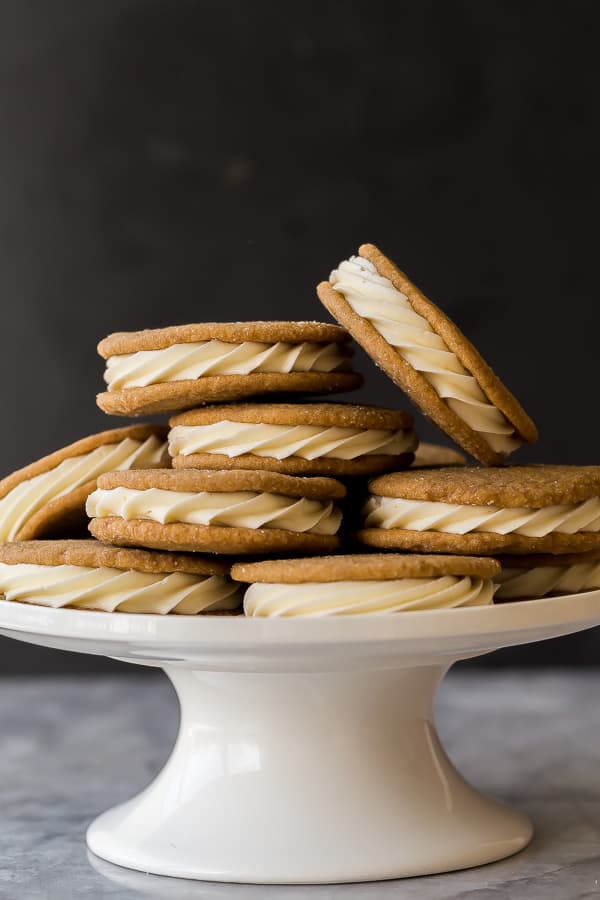 white chocolate gingersnap oreos piled on a white cake plate