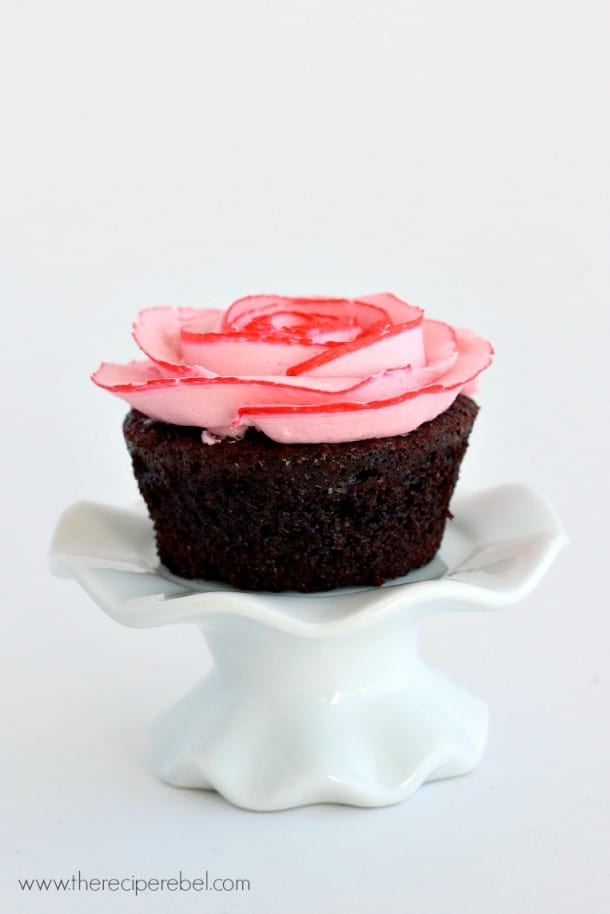 one chocolate cupcake with two tone buttercream rose on white cupcake stand