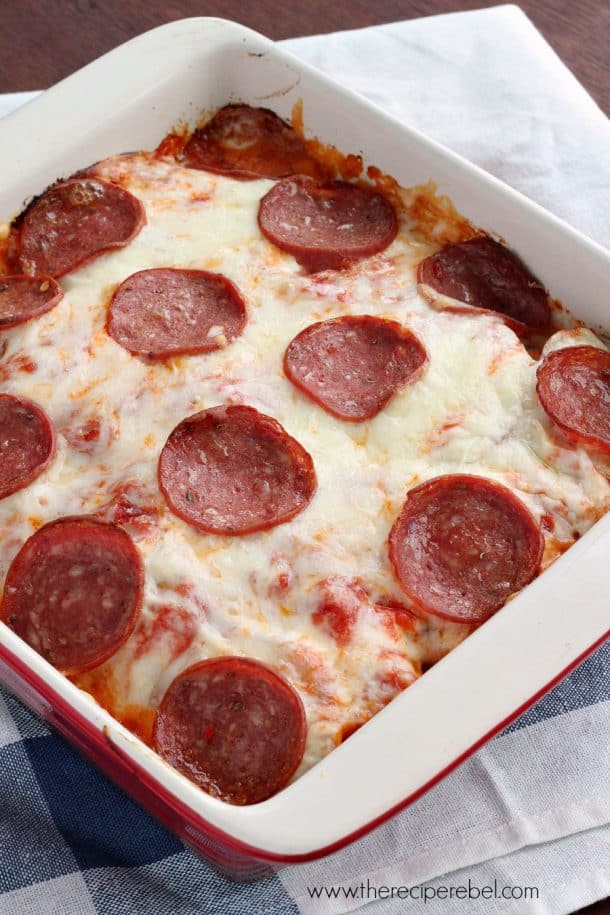 white and red baking dish filled with pepperoni pizza scalloped potatoes