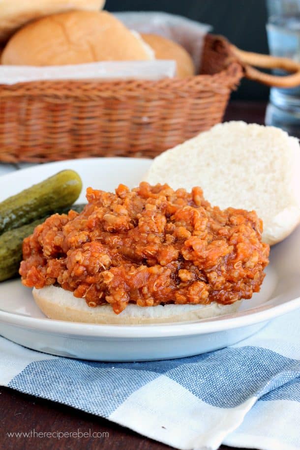 barbecue chicken quinoa sloppy joes on open bun on white plate with pickles