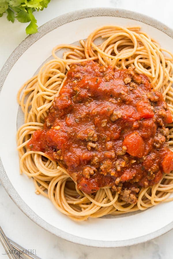 crockpot spaghetti sauce overhead on grey and white plate and marble background