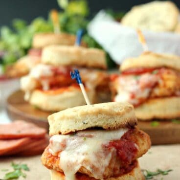 Chicken Pizziola Sliders on Garlic Herb Biscuits: perfect oven-fried chicken topped with pizza sauce, pepperoni and cheese and piled high on a flaky, homemade biscuit. It doesn't get better than this! www.thereciperebel.com