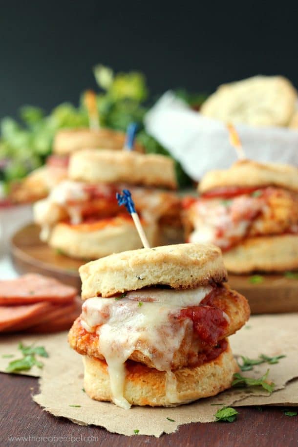 close up image of chicken pizziola slider on biscuit with toothpick stuck in the top