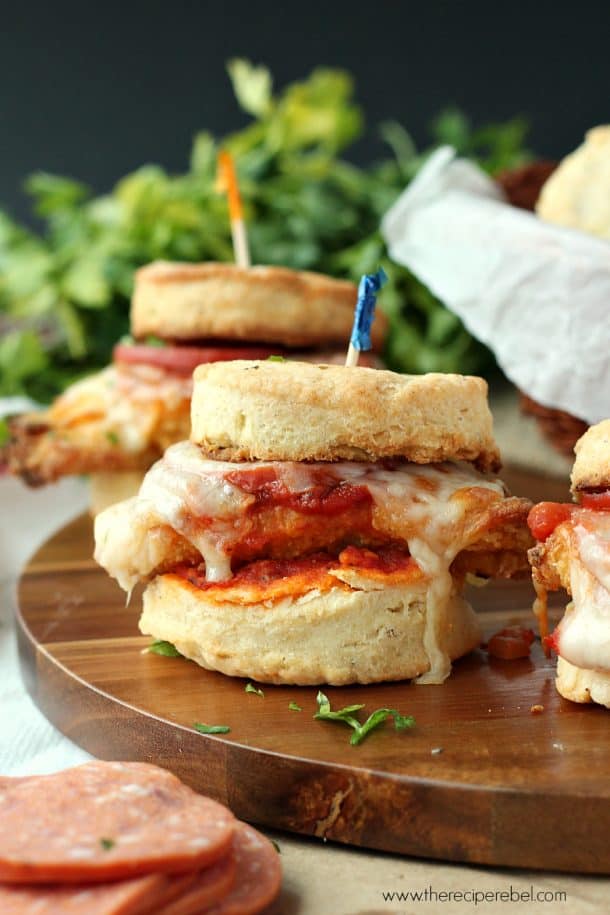 biscuit sandwich stuffed with fried chicken pizza with tomato sauce and mozzarella cheese on wood cutting board