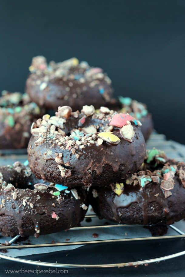 stack of three double chocolate easter candy baked donuts on wire cooling rack