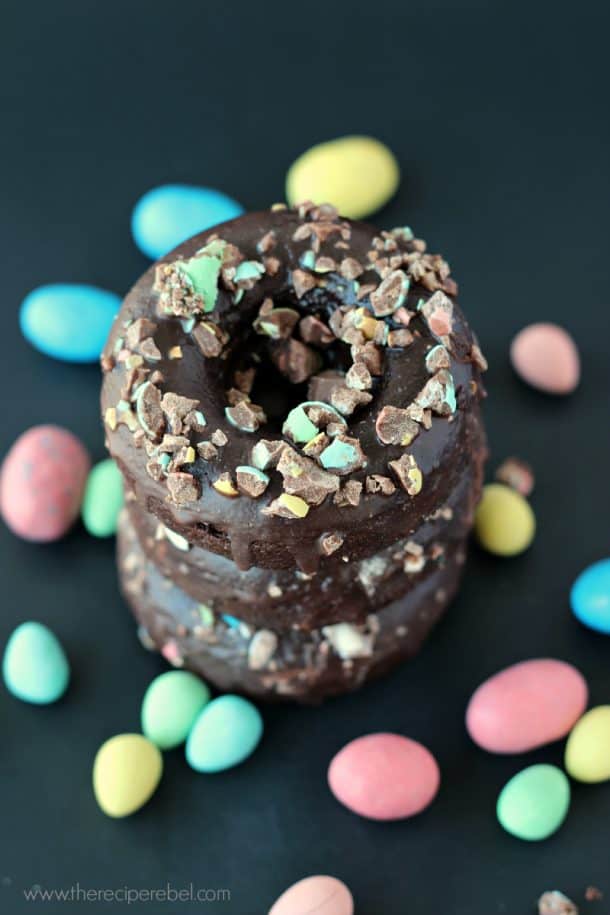 overhead image of stack of three double chocolate baked donuts with crushed easter candy