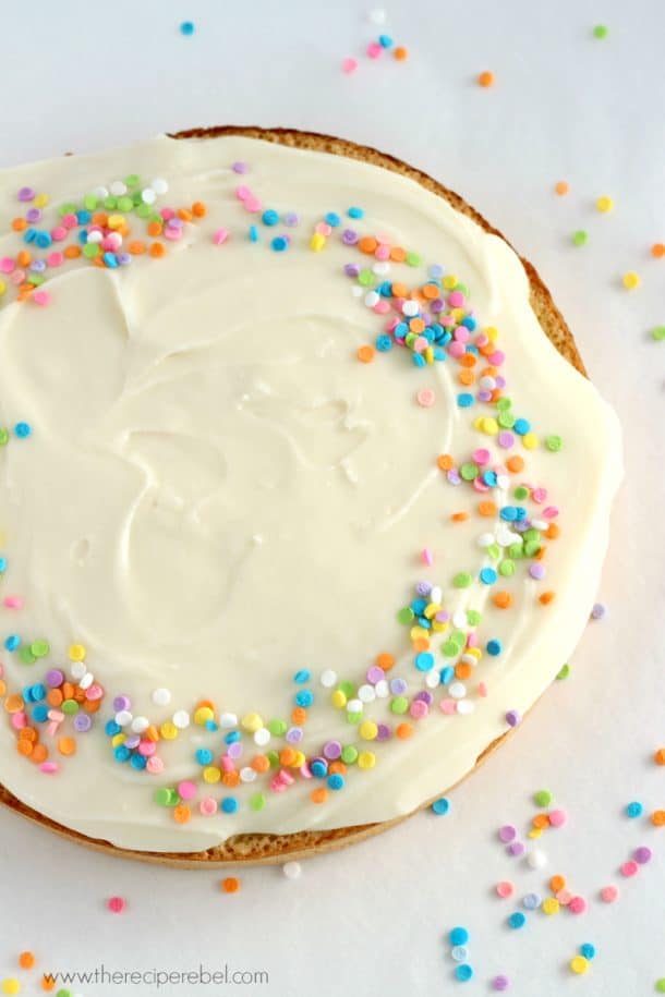 overhead image of gluten free coconut cake with cream cheese frosting and sprinkles