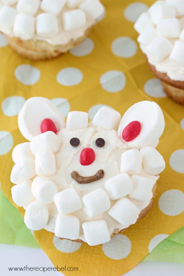 close up of cupcake with vanilla frosting and mini marshmallows to look like a lamb