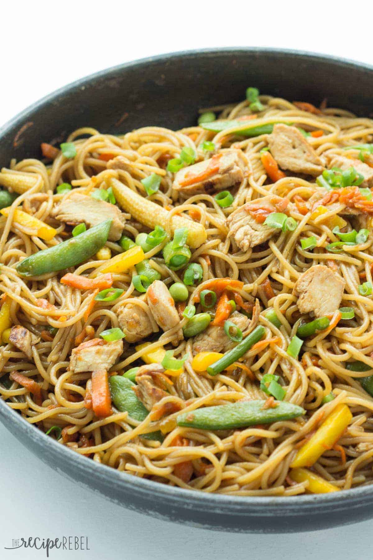 black skillet with one pot chicken chow mein with snap peas peppers and baby corn
