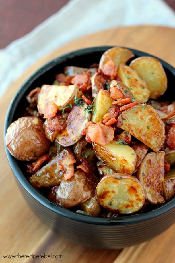 maple bacon potato salad with roasted potatoes in black bowl topped with bacon