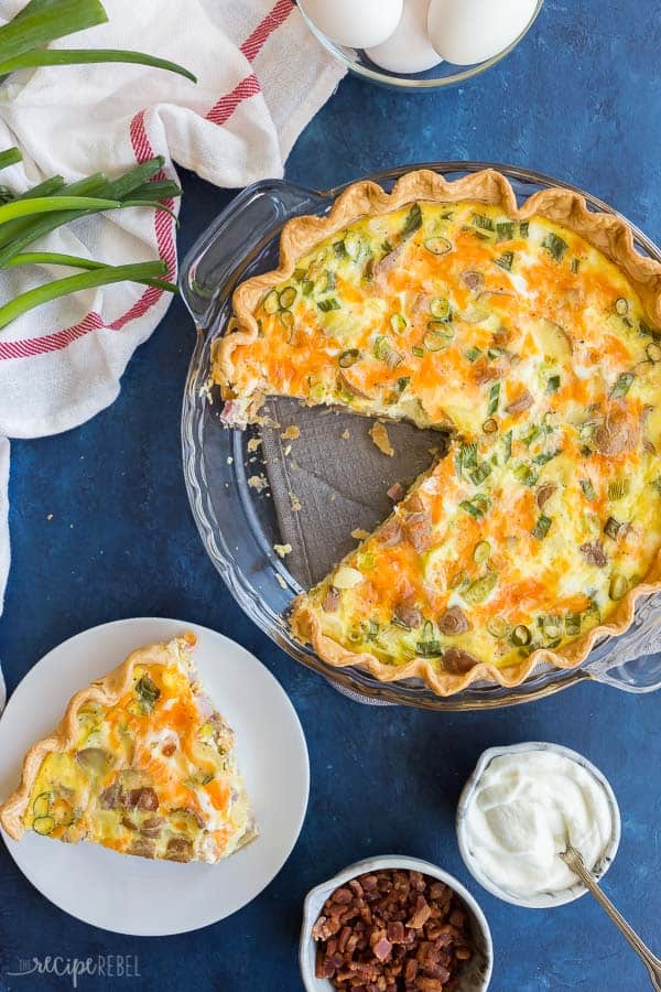 easy quiche recipe overhead in glass pie plate with a piece taken out and put on a white plate