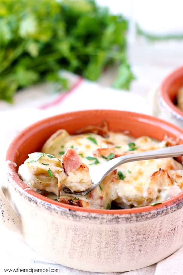 chicken cordon bleu scalloped potatoes in brown bowl with spoon scooping potatoes