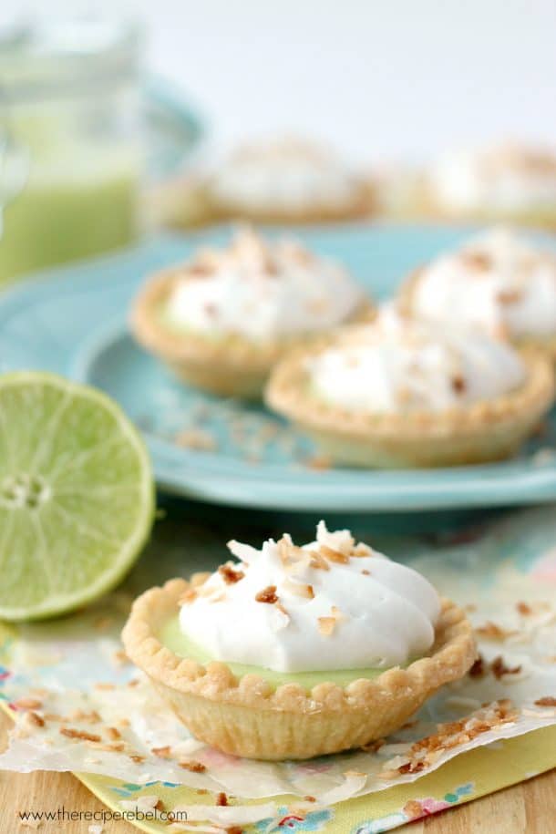 coconut lime tart whole on colorful napkin in front of plate with more tarts