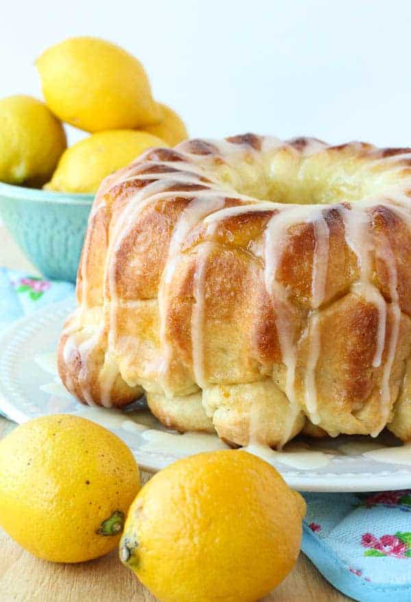lemon monkey bread covered in glaze with whole lemons all around