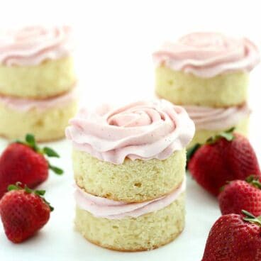 Mini Vanilla Layer Cakes with Strawberry Swiss Meringue Buttercream: the perfect moist vanilla cake and fluffy not-too-sweet strawberry frosting! Great for any birthday or Spring celebration. www.thereciperebel.com
