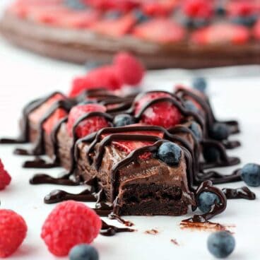 Nutella Brownie Fruit Pizza: a Nutella and cream cheese filling on a fudgy brownie base, topped with tons of fresh berries! Chocolate fruit pizza is the best kind! www.thereciperebel.com