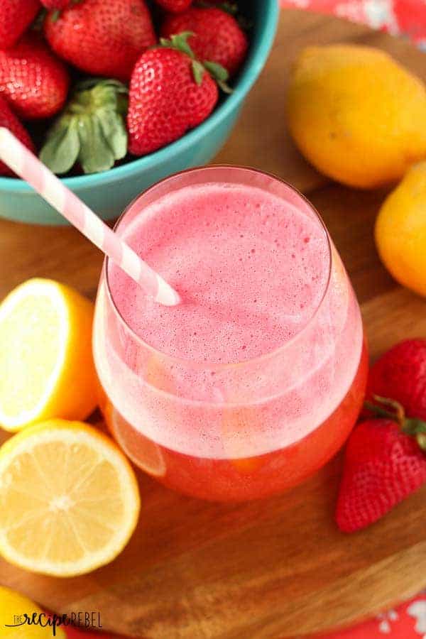 overhead image of pink slush in glass with strawberries and lemons around