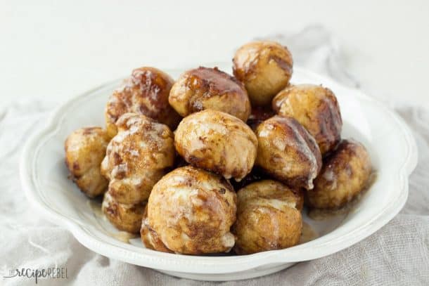 white bowl filled with cinnamon sugar coated pretzel bites drizzled with glaze