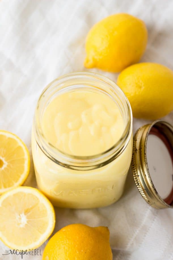 Easy Homemade Lemon Curd: made completely in one pot. The easiest method! The perfect addition of fresh citrus to any dessert! www.thereciperebel.com homemade lemon curd in glass mason jar with lemons all around