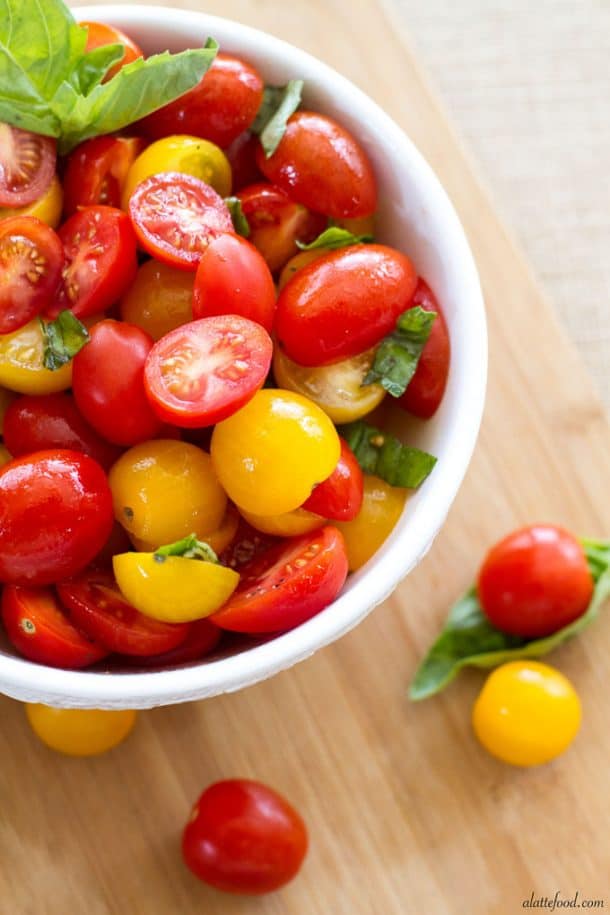 fresh tomato basil salad in white bowl with cherry tomatoes