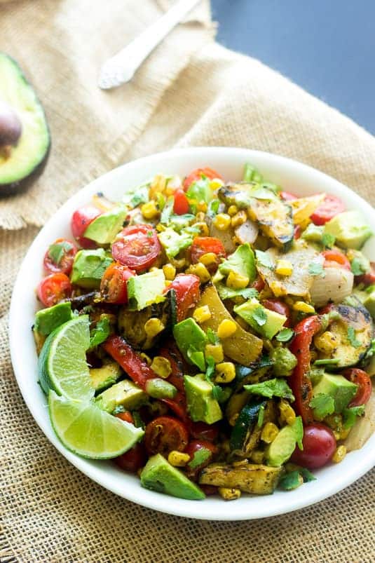 grilled corn salad with tomato and avocado in white bowl