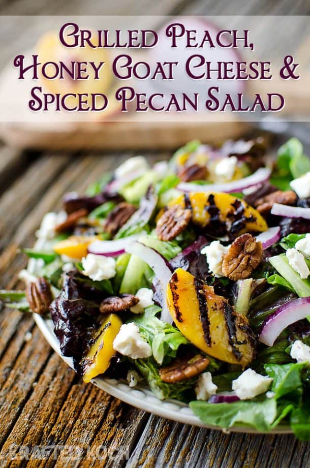 grilled peach honey goat cheese salad piled on a white plate on a rustic background