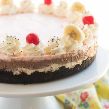 3 fruity cheesecake layers make up this easy, No-Bake Banana Split Cheesecake: banana pineapple, strawberry and chocolate! The perfect summer dessert!