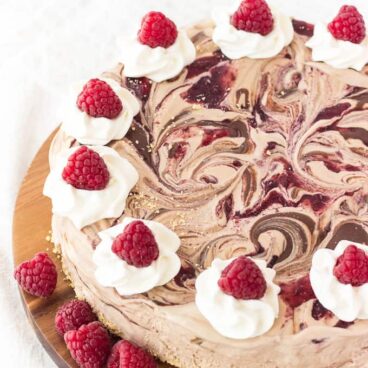 An easy ice cream cake made 3-ingredient no-churn chocolate ice cream swirled with Nutella and raspberry preserves. All on a crust made with crushed ice cream cones! The perfect simple, no-bake summer dessert!