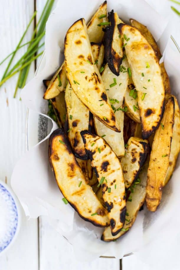 salt and vinegar grilled potato wedges in basket lined with parchment paper