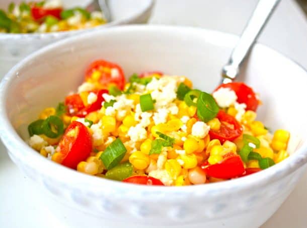 sweet corn salad with cherry tomatoes and lime topped with green onions