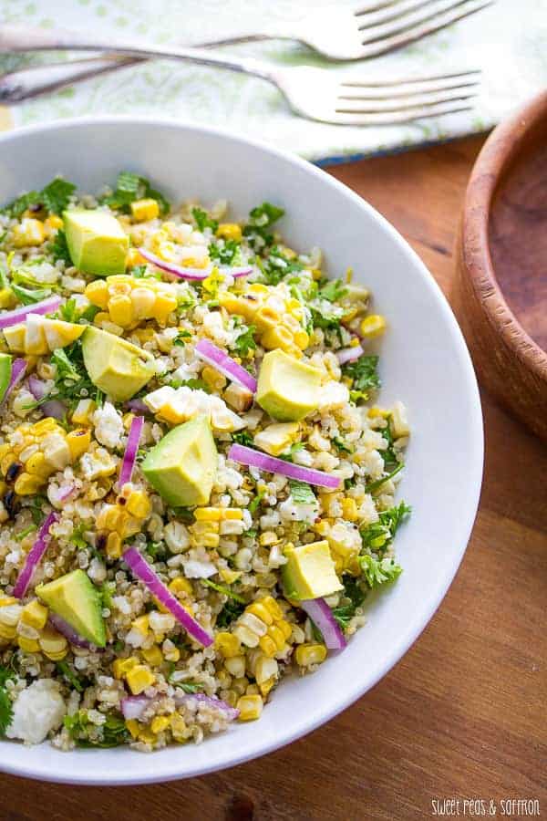charred corn salad with avocado and red onion in white bowl