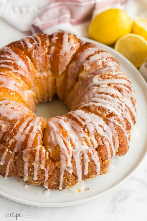 This Glazed Lemon Monkey Bread is made with homemade bun dough rolled in lemon sugar, baked, and covered in a thick lemon glaze. The perfect make ahead breakfast, brunch or dessert! #lemon #bread #breakfast #baking lemon monkey bread finished with glaze