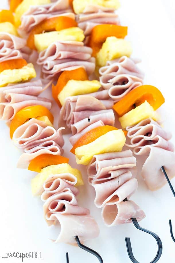 image of skewers before grilling with ham strips pineapple chunks and orange peppers