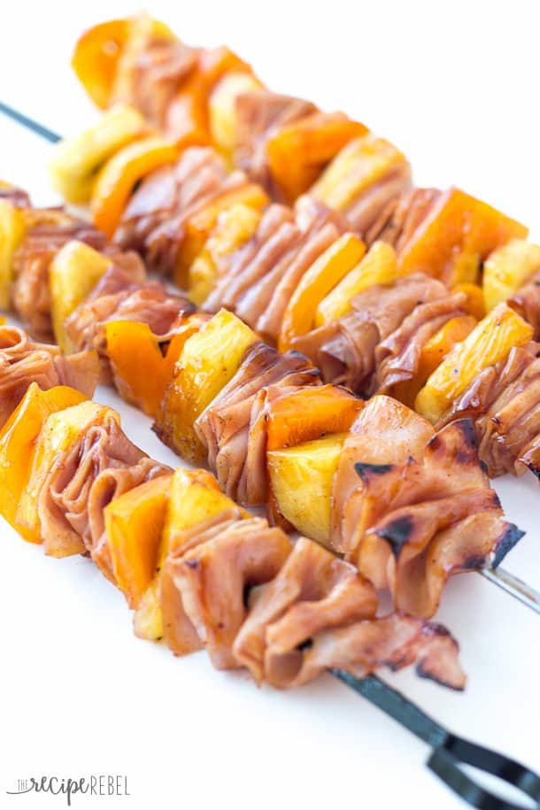 All kinds of kabob recipes for summer grilling! Chicken kabobs, shrimp kabobs, steak kabobs, and dessert kabobs! Because food on a stick is more fun ;) ham and pineapple skewers on metal skewers on white background