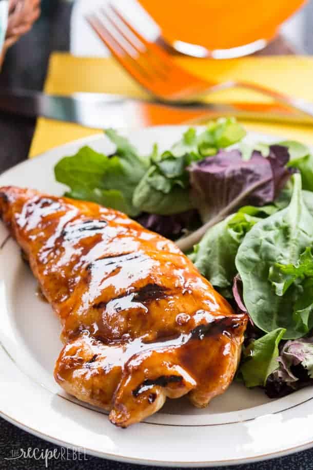 chicken breast with honey balsamic glaze on white plate with fresh greens