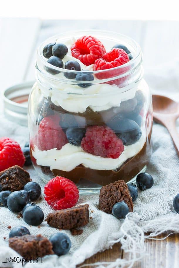 raspberry and blueberry brownie trifle layered with chocolate pudding and whipped topping in jar