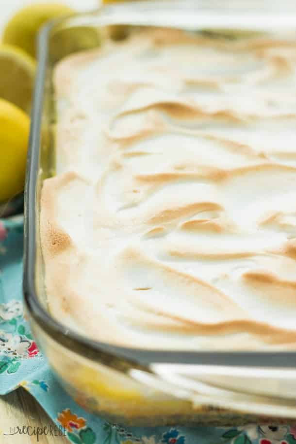 glass pan with skinny lemon meringue poke cake topped with toasted meringue