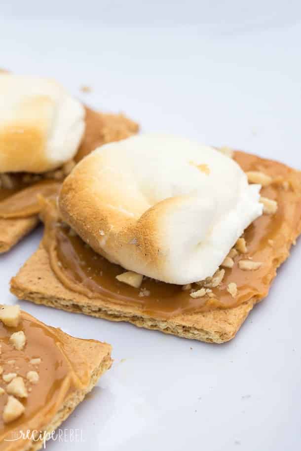 toasted marshmallow on graham cracker that has been spread with peanut butter caramel and chopped peanuts