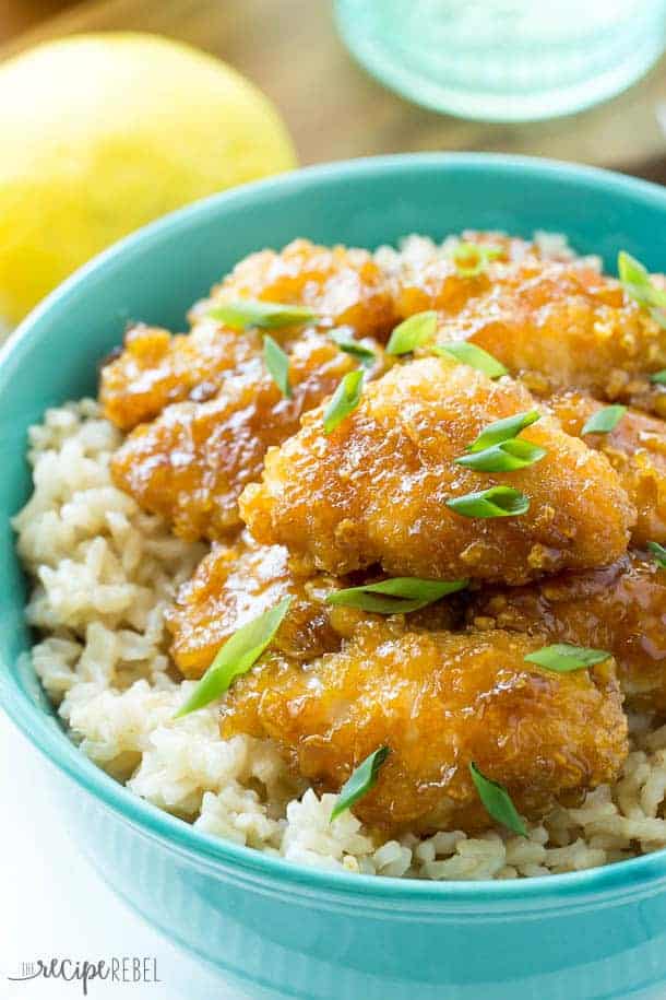 baked honey lemon chicken in bright blue bowl over a bed of rice