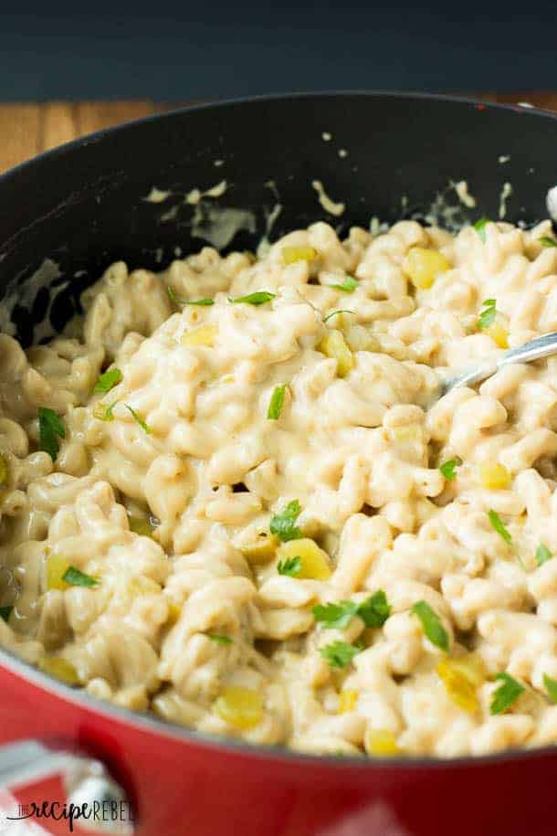 close up image of green chile mac and cheese in large red and black pot